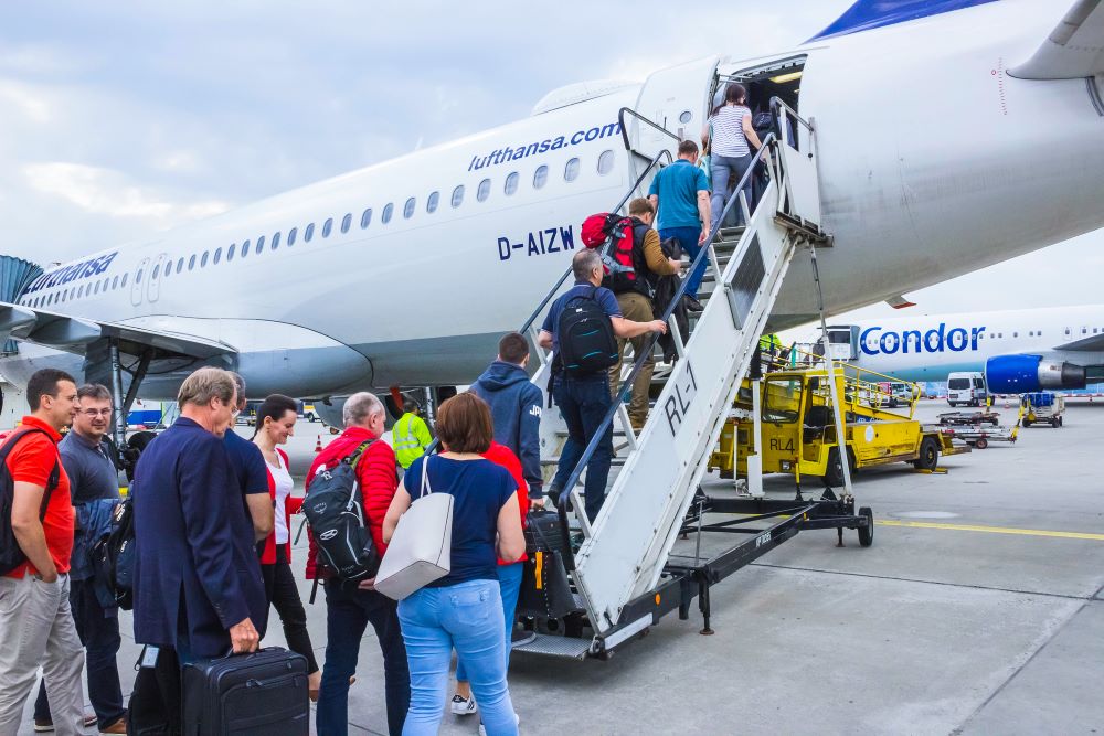 Passagiere betreten die Lufthansa Maschine mit Handgepäck